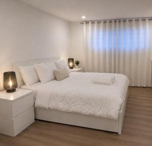 a white bedroom with a white bed and a window at Okanagan Valley Beautiful 2 beds 2 bath in Vernon