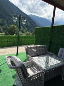 a patio with a table and chairs and a lamp at Konçoğlu Pansiyon in Uzungöl