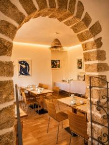 a restaurant with tables and chairs and a stone wall at Hotel Cayrons Vence & St Paul de Vence in Vence