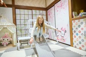 a little girl playing on a slide in a room at Numazu Sparkle in Numazu
