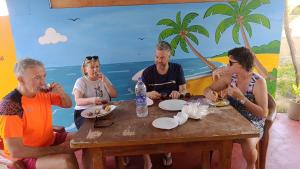 a group of people sitting around a wooden table at New Guest in Nilaveli
