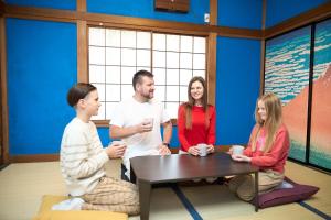 a group of people sitting around a table in a room at Numazu Sparkle in Numazu