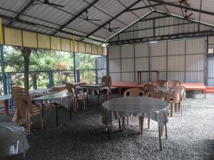 a group of tables and chairs in a building at Kuttickattil Gardens Homestay in Kottayam
