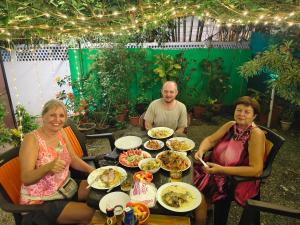 a group of people sitting at a table with food at Dver Prirody in Kovalam