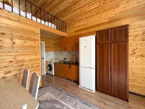 a kitchen with a white refrigerator and wooden walls at Naryn Barnhouses in Naryn +31 photos