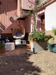 a wicker chair sitting on a patio next to a building at Vincenzo le cyclo in Kientzheim