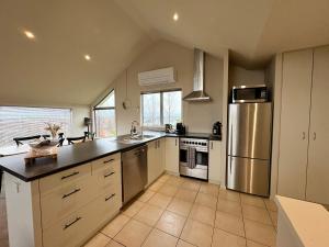 a large kitchen with a stainless steel refrigerator at Mountain Views on the Reserve in Wanaka