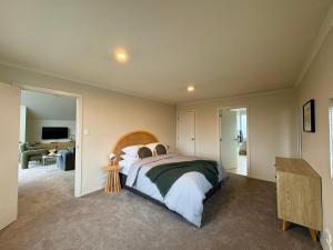 a bedroom with a large bed and a desk at Mountain Views on the Reserve in Wanaka