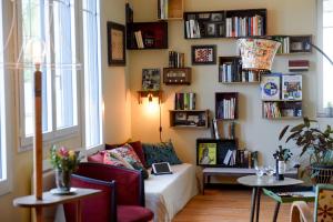 a living room with a couch and a shelf of books at L'en vert appartement in Bagnères-de-Bigorre