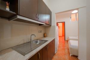 a kitchen with a sink and a bed in a room at Unico ApartHotel in Sarandë