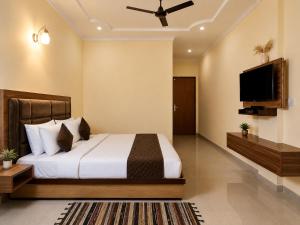 a bedroom with a bed and a flat screen tv at Hotel Valna Estate Himalyan View Kausani By HRG in Kausani