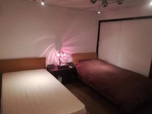 a bedroom with two beds and a lamp on a table at Hitsujipotchi-Kyoto in Yatsuai