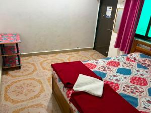a bedroom with a bed with red and blue at SH Guest House Malvan in Malvan