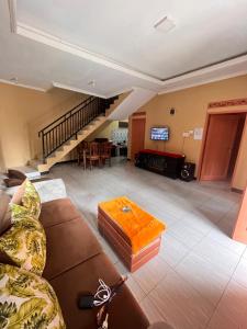 a living room with a couch and a tv at Villa Pondok Aurora in Campaka +4 photos