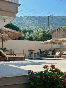 a patio with umbrellas and tables and chairs at Anestis Studios in Lidia
