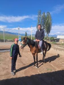 a man standing next to a man on a horse at Kamas Guesthouse in Kyzart