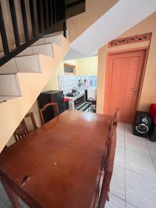 a dining room with a table and a red door at Villa Pondok Aurora in Campaka