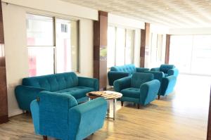 a waiting room with blue chairs and a table at Nachiappa in Kodaikānāl
