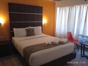 a bedroom with a bed with two towels on it at Nachiappa in Kodaikānāl
