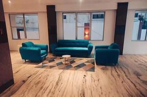 a lobby with two blue couches and a table at Nachiappa in Kodaikānāl