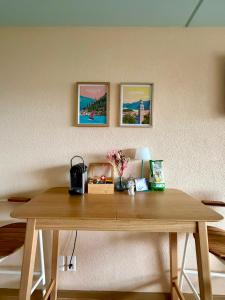 a wooden table in a room with pictures on the wall at Ticino Lakeview Apartment in Bissone +24 photos