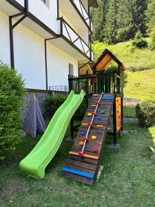 a playground with a slide in a yard at TRIIBRIA Guest house in Trigrad