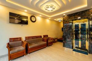 a waiting room with couches and a clock on the wall at Meeraa Residency in Rāmeswaram