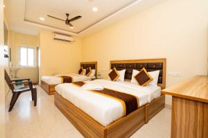 a hotel room with two beds and a desk at Meeraa Residency in Rāmeswaram +43 photos