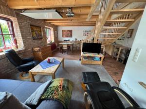 a living room with a couch and chairs and a tv at Café Landart im Thüringer Finistère in Plaue