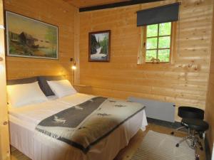 a bedroom with a bed in a wooden room at Villa Visioduuri in Savonlinna