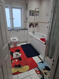 a bathroom with a mickey mouse rug on the floor at Wembley Stadium Room with Parking and Breakfast in London +4 photos