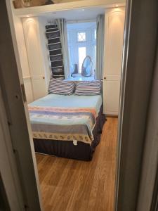 two beds in a small room with a window at Wembley Stadium Room with Parking and Breakfast in London