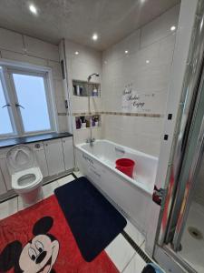 a bathroom with a toilet and a tub and a sink at Wembley Stadium Room with Parking and Breakfast in London