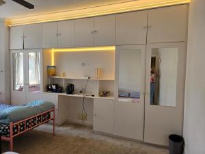 a bedroom with white cabinets and a bed at Wembley Stadium Room with Parking and Breakfast in London