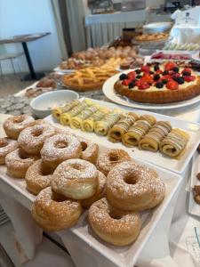 a display case with different types of donuts and pastries at Hotel Caraibi - Breakfast Until 11-00 and Dinner-Mirabilandia Partner in Milano Marittima