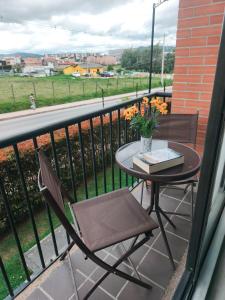 a table and chairs on a balcony with a view of a field at Faro 1, Parque Jaime Duque, Autódromo Tocancipá in Tocancipá