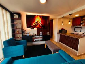 a living room with a blue couch and a tv at Faro 1, Parque Jaime Duque, Autódromo Tocancipá in Tocancipá