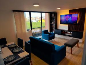 a living room with a couch and chairs and a tv at Faro 1, Parque Jaime Duque, Autódromo Tocancipá in Tocancipá
