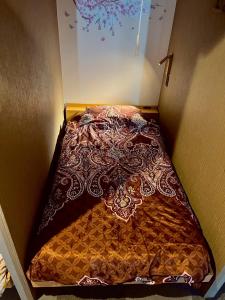 a bed in a corner of a room at ゲストハウスブルーオーシャン那覇 in Naha