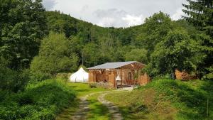 a barn and a white tent in a forest at Old Mill Glamp in Kozov
