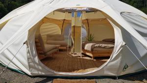 a tent with a bed and a chair in it at Old Mill Glamp in Kozov