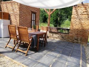 a patio with a table and chairs under a white tent at Old Mill Glamp in Kozov +1 photo