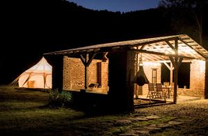 a small brick house with a tent in the dark at Old Mill Glamp in Kozov
