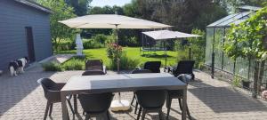 eine Terrasse mit Tisch, Stühlen und Sonnenschirm in der Unterkunft Ravito in Peissant