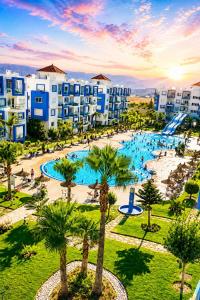 an aerial view of a resort with a pool and palm trees at Résidence Kariat Cabo 2-bedroom apartment in Cabo Negro