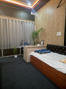 a bedroom with a bed in a room with potted plants at Hotel Gopal Palace in Khātu