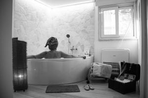 a person in a bath tub in a bathroom at Rosu in Triggiano +29 photos
