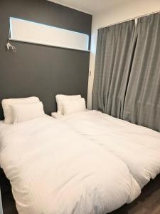 two white beds in a room with a window at Kichi in Tokyo
