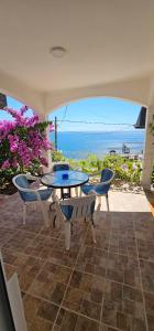 a patio with a table and chairs and the ocean at Apartmani MAS in Dobra Voda