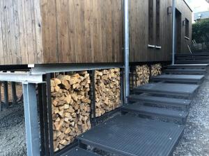 a pile of fire wood next to a fence at Exklusive Ferienlodge in Wertheim +7 photos